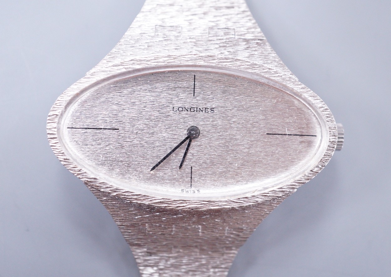 A lady's 1970's silver Longines manual wind wrist watch, with oval dial, on a textured silver bracelet.
